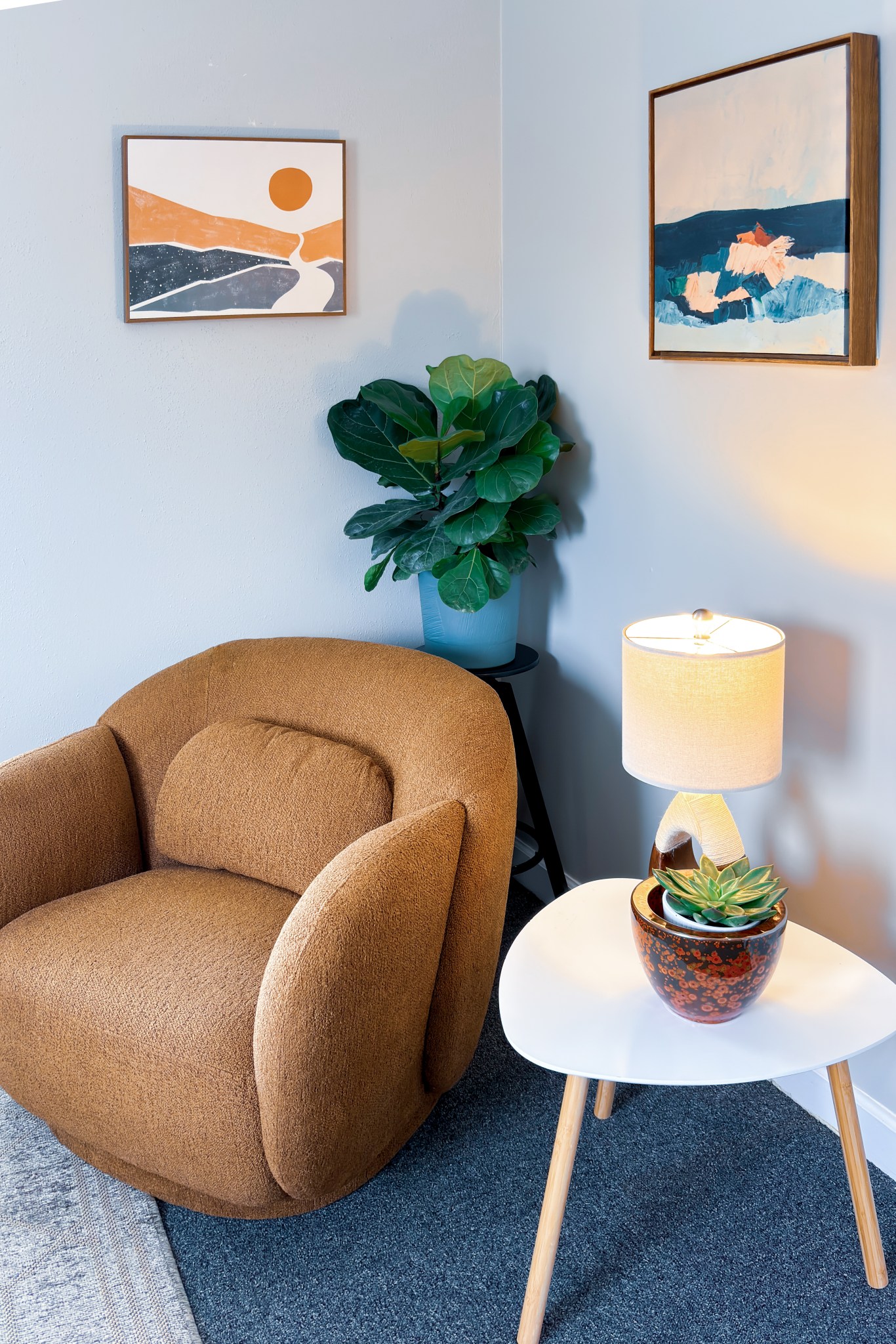 Cozy office corner with a brown armchair, artwork, and lamp